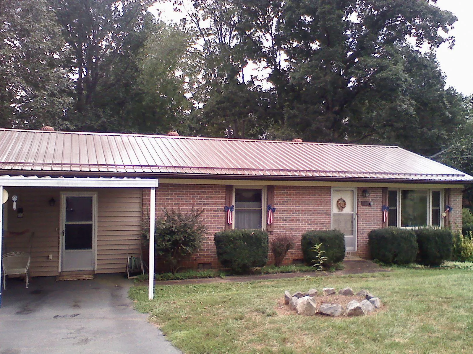 Bronze metal roof and carport on a brick ranch home in Clayville